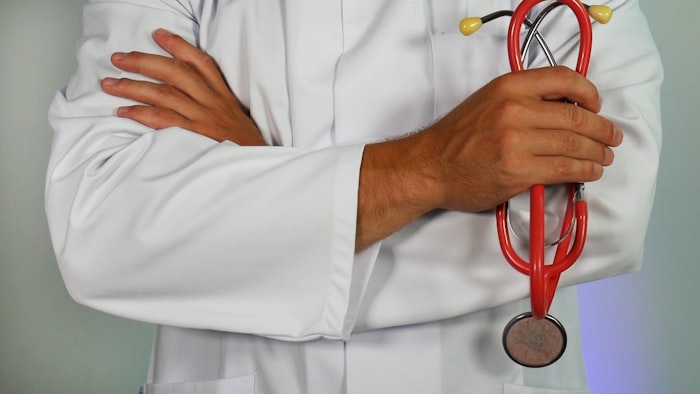 Clinician in a white coat holding a stethoscope.